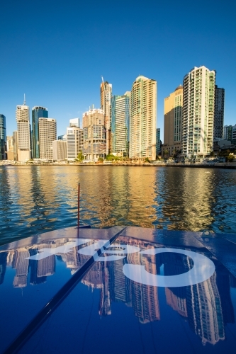 Brisbane city apartments reflected on the hull of a CityCat travelling on the Brisbane River - Australian Stock Image