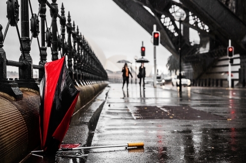 Broken umbrella on city street during Sydney rain storm
