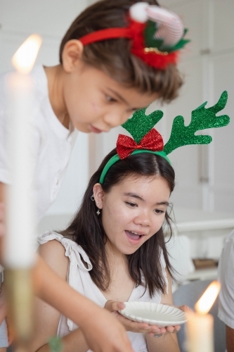 Brother and sister dishing up food onto plate - Australian Stock Image