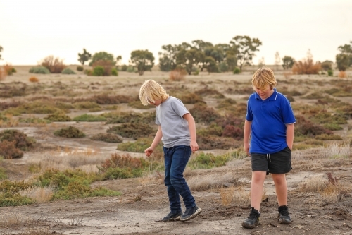 Brothers walking together exploring desolate dry lake. Family outing in the Australian bush. - Australian Stock Image