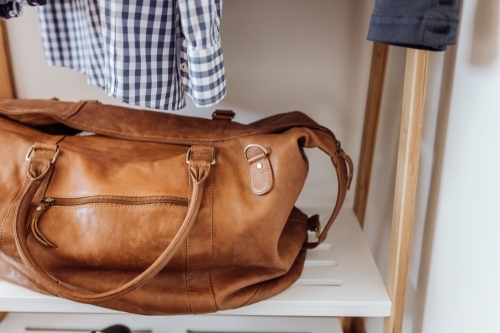Brown leather handbag on shelf