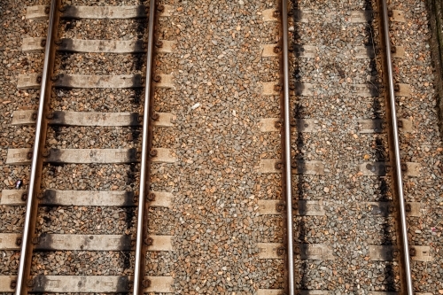 Brown railway tracks and gravel with sleepers and rails