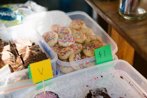 Brownies and sprinkled cookie in a white container with a $1 sign