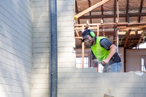 Builder working on window space on new house - Australian Stock Image