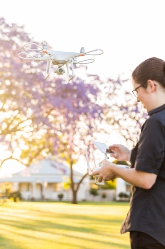 Businesswoman flying RPA drone in suburban area - Australian Stock Image