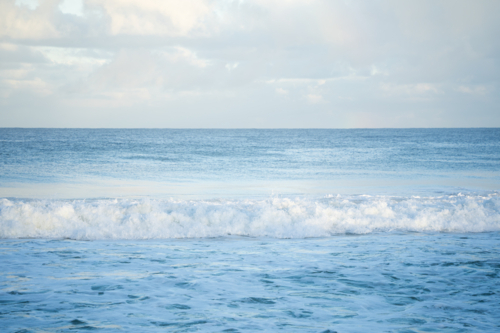 Calm open ocean water and blue sky horizon at Scarborough Beach, Perth, Western Australia - Australian Stock Image
