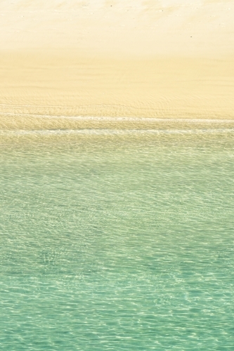 Calm seawater gentle lapping on a sandy beach - Australian Stock Image