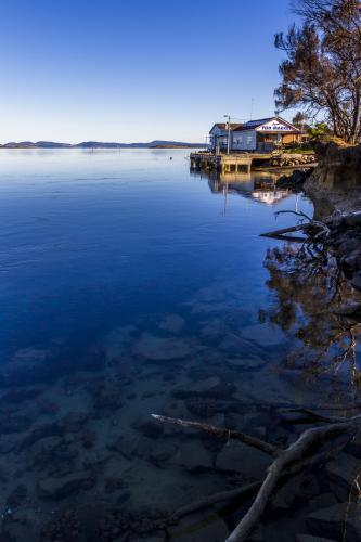 Calm water with fish market in the background. - Australian Stock Image