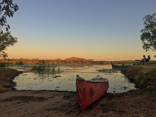 Canoe beside lake at sunset - Australian Stock Image