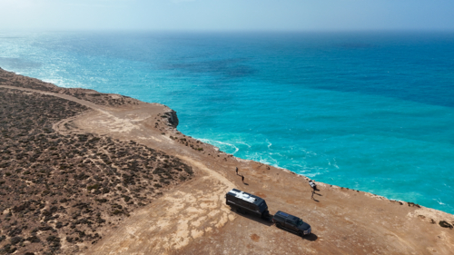 Car and caravan parked up on the edge of cliffs by the ocean - Australian Stock Image