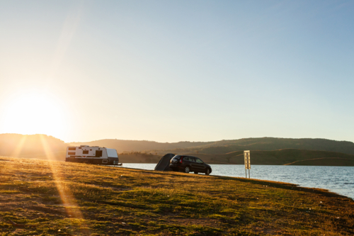 Car caravan and tent along the shoreline of inland lake in Australia - Australian Stock Image