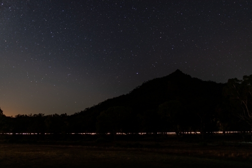 Car light trail along base of hill - Australian Stock Image