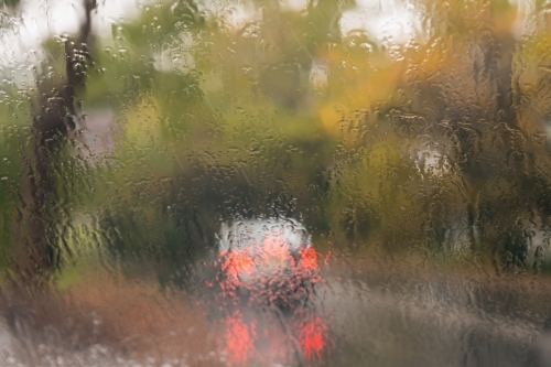 car lights seen through a wet windscreen, with autumn colours - Australian Stock Image