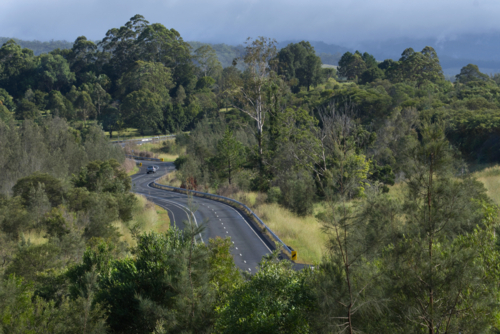 Car on country road with bends on a sunny day - Australian Stock Image