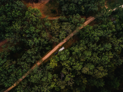 Car with caravan pulled off to the side of dirt trail in forested area in rural NSW Australia - Australian Stock Image