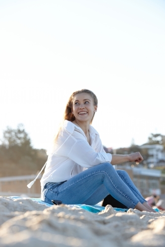 Carefree young blonde-haired woman at beach enjoying the sunshine - Australian Stock Image