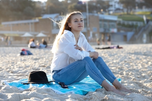 Carefree young blonde-haired woman at beach enjoying the sunshine - Australian Stock Image