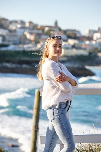 Carefree young blonde haired woman at beach wearing sunglasses