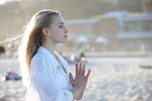 Carefree young blonde woman at beach enjoying the sunshine - Australian Stock Image
