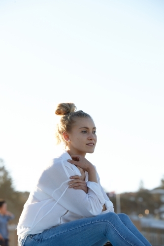 Carefree young blonde woman at beach enjoying the sunshine - Australian Stock Image