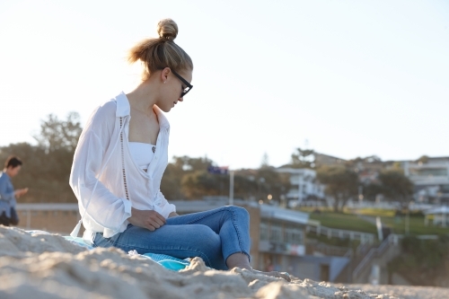 Carefree young blonde woman at beach enjoying the sunshine - Australian Stock Image