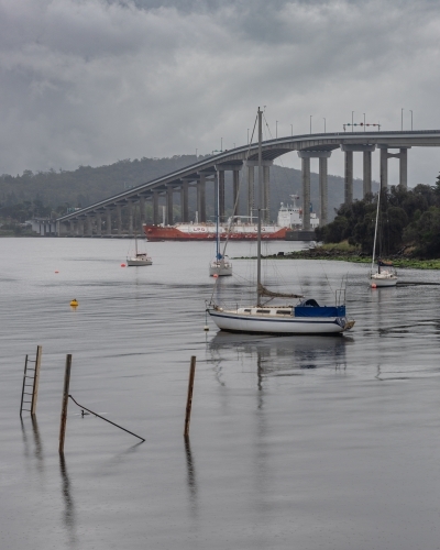 Cargo ship passing under the Tasman Bridge, Hobart, Tasmania - Australian Stock Image