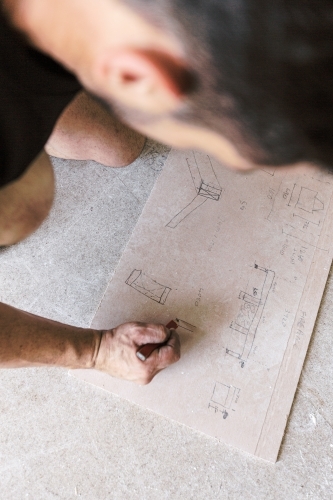 Carpenter doing construction hand sketch and drawing - Australian Stock Image