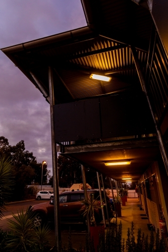 Cars parked outside shop front with warm lights. - Australian Stock Image