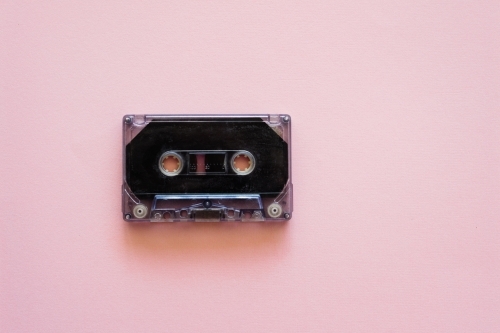 cassette music tape on pink background - Australian Stock Image