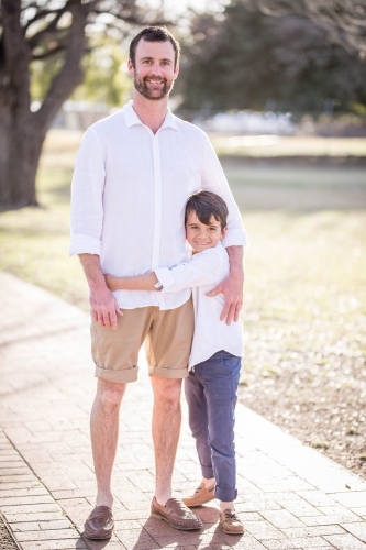 Caucasian father standing with arm around mixed race aboriginal son - Australian Stock Image