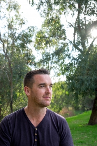 Caucasian male looking into the Distance surrounded by Trees - Australian Stock Image