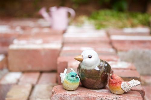 Ceramic bird statuettes of birds sittings on a pile of bricks - Australian Stock Image