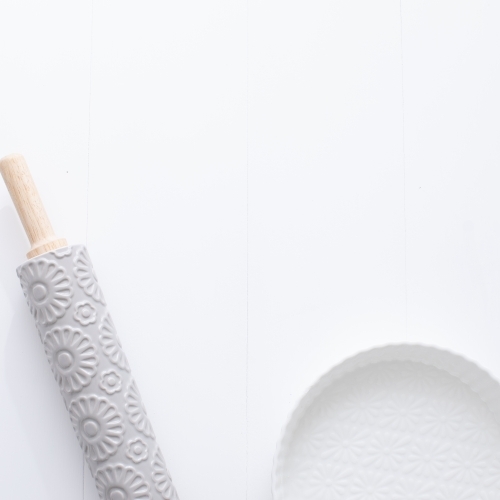 Ceramic pie dish and rolling pin on blank background - Australian Stock Image