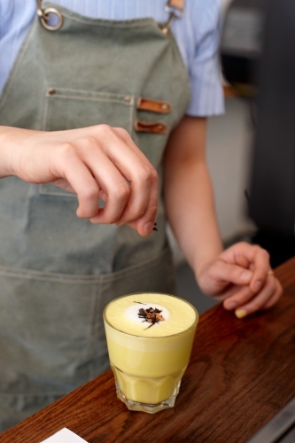 Chai and turmeric tea latte prepared on table in cafe - Australian Stock Image