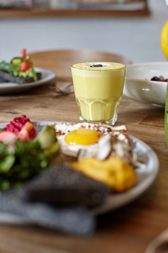 Chai latte and healthy lunch on table in cafe - Australian Stock Image