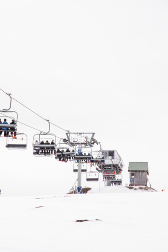 Chairlift with lots of skiiers going up mountain - Australian Stock Image