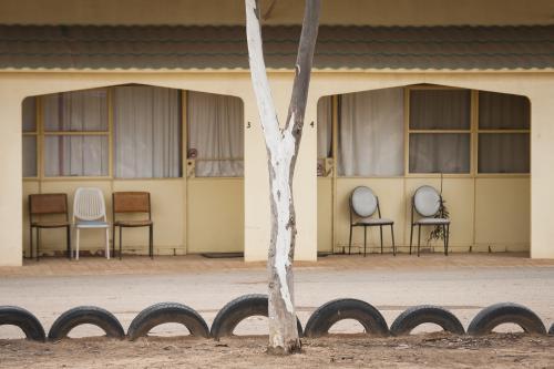 Chairs outside a pale yellow motel on the Nullarbor