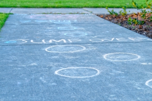 Chalk drawings on the pavement at a play park - Australian Stock Image