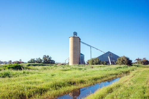 Channel with silos in background on a blue sky day. - Australian Stock Image