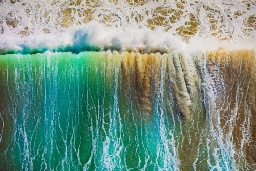 Chaotic surf churning up the sand at Wanda Beach - Australian Stock Image