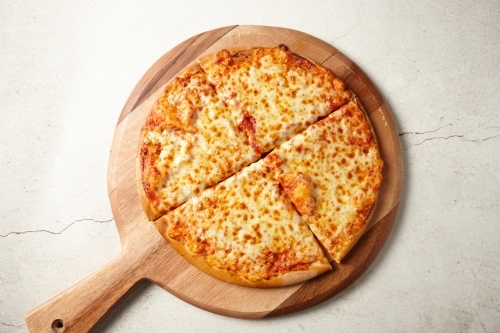 Cheese and tomato pizza on board - Australian Stock Image
