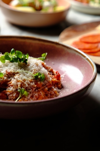 Cherry tomato sugo risoni in a pink bowl - Australian Stock Image