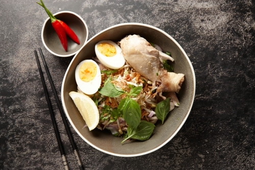 Chicken pho soup ingredients in bowl on table - Australian Stock Image
