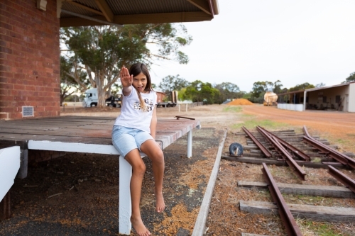 child near disused railway line holding out hand in stop signal - Australian Stock Image