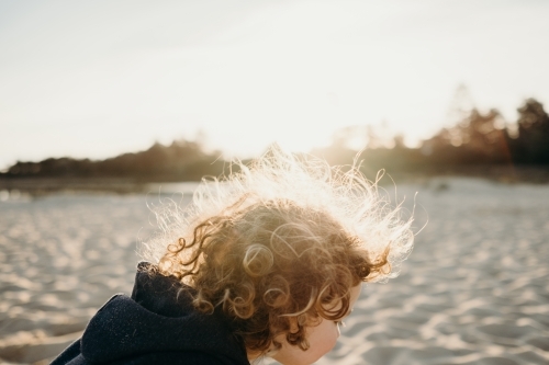 child on beach at sunset