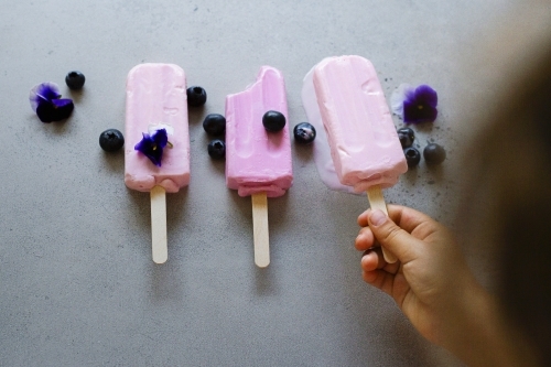 Child picking up ice cream - Australian Stock Image
