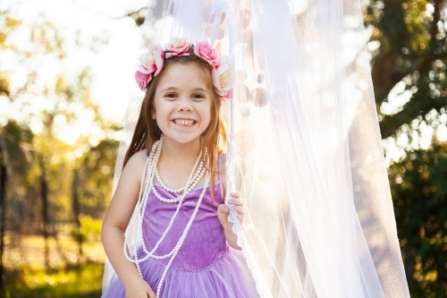 Child playing dress ups as princess with pearl necklace - Australian Stock Image