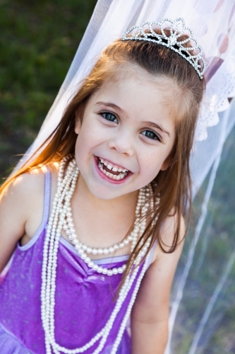 Child playing dress ups as princess with pearl necklace - Australian Stock Image