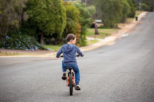 a boy on a bike with no helmet Image of School boy riding his bike home from school