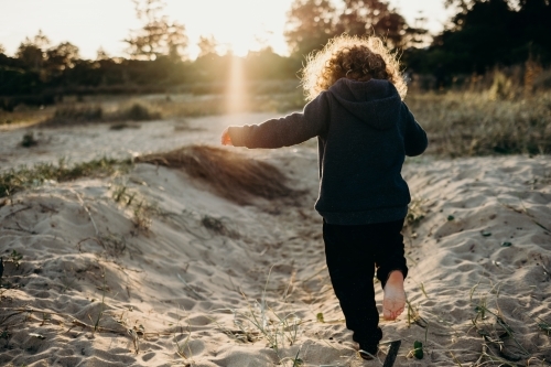 child running away on beach - Australian Stock Image